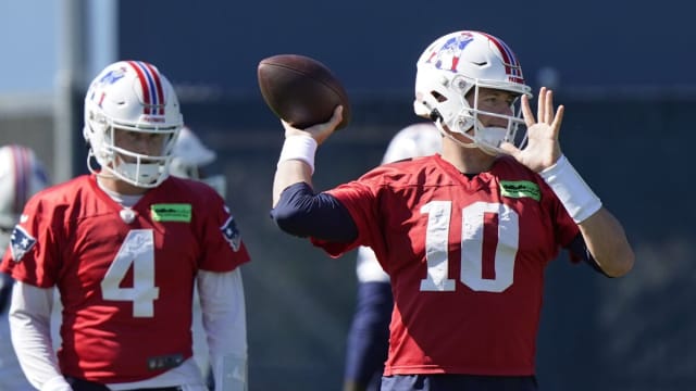 New England Patriots quarterback Mac Jones (10) winds up to pass as quarterback Bailey Zappe (4) looks on during an NFL football practice